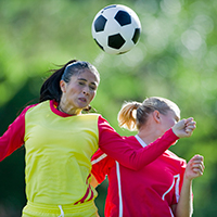 women soccer player heading the ball