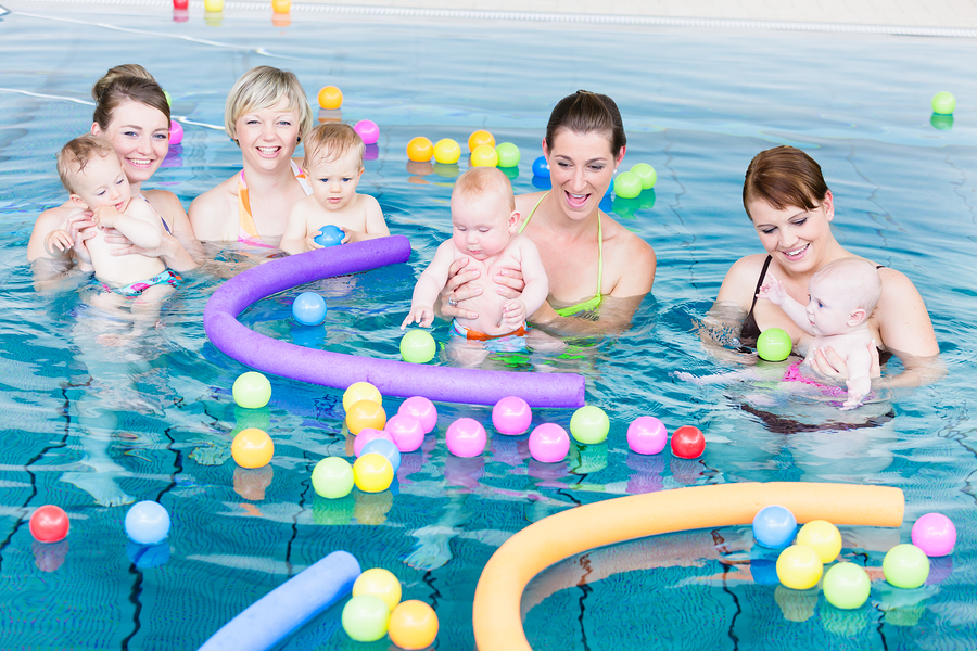 Moms and newborns playing in a pool 