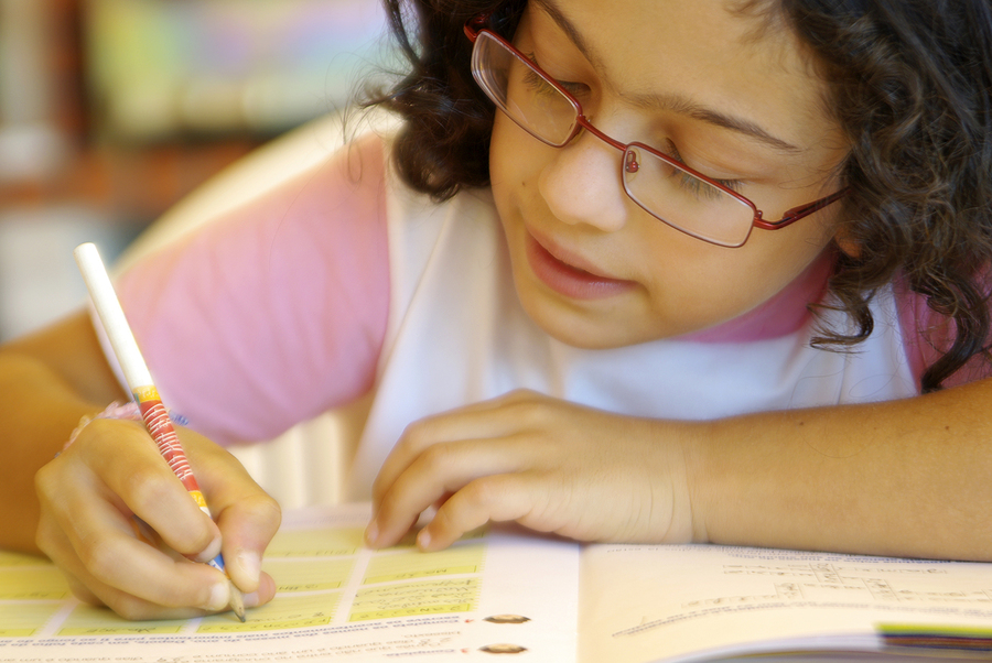 close up of a girl filling out a workbook