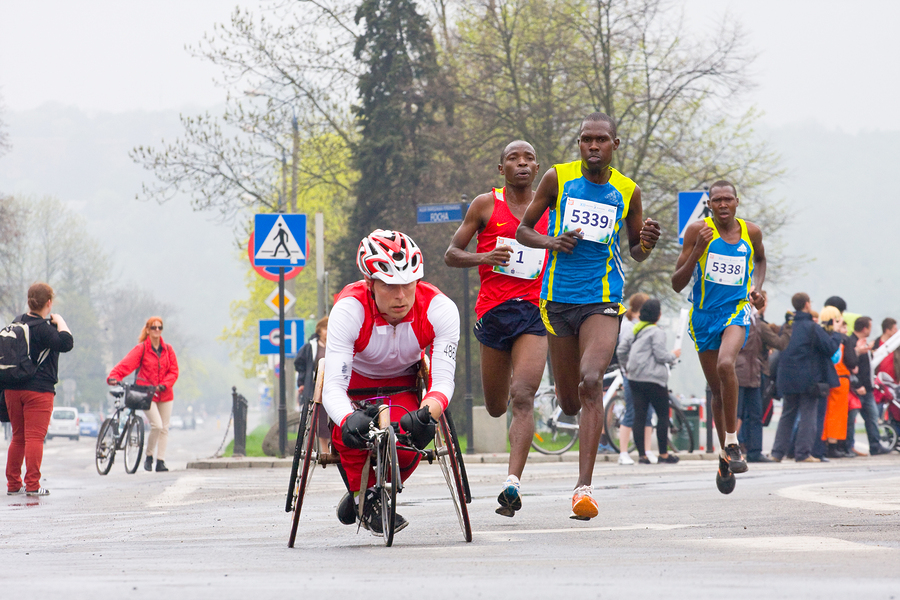 Wheelchair racer passing elite runners in marathone