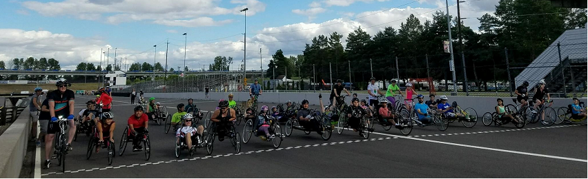 Fifty handcyclist lining up at the Portland International Raceway startline at the beginning of a PDX Summer Handcycling Program