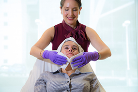 Aesthetician with a client doing a facial.
