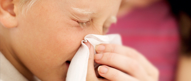 Child blowing nose into tissue