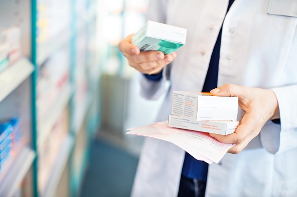 pharmacist holding various boxes