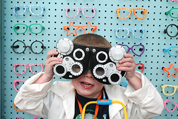 A child plays with eye exam equipment.