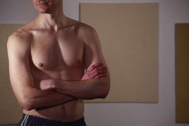 A man showing off his hairless chest.