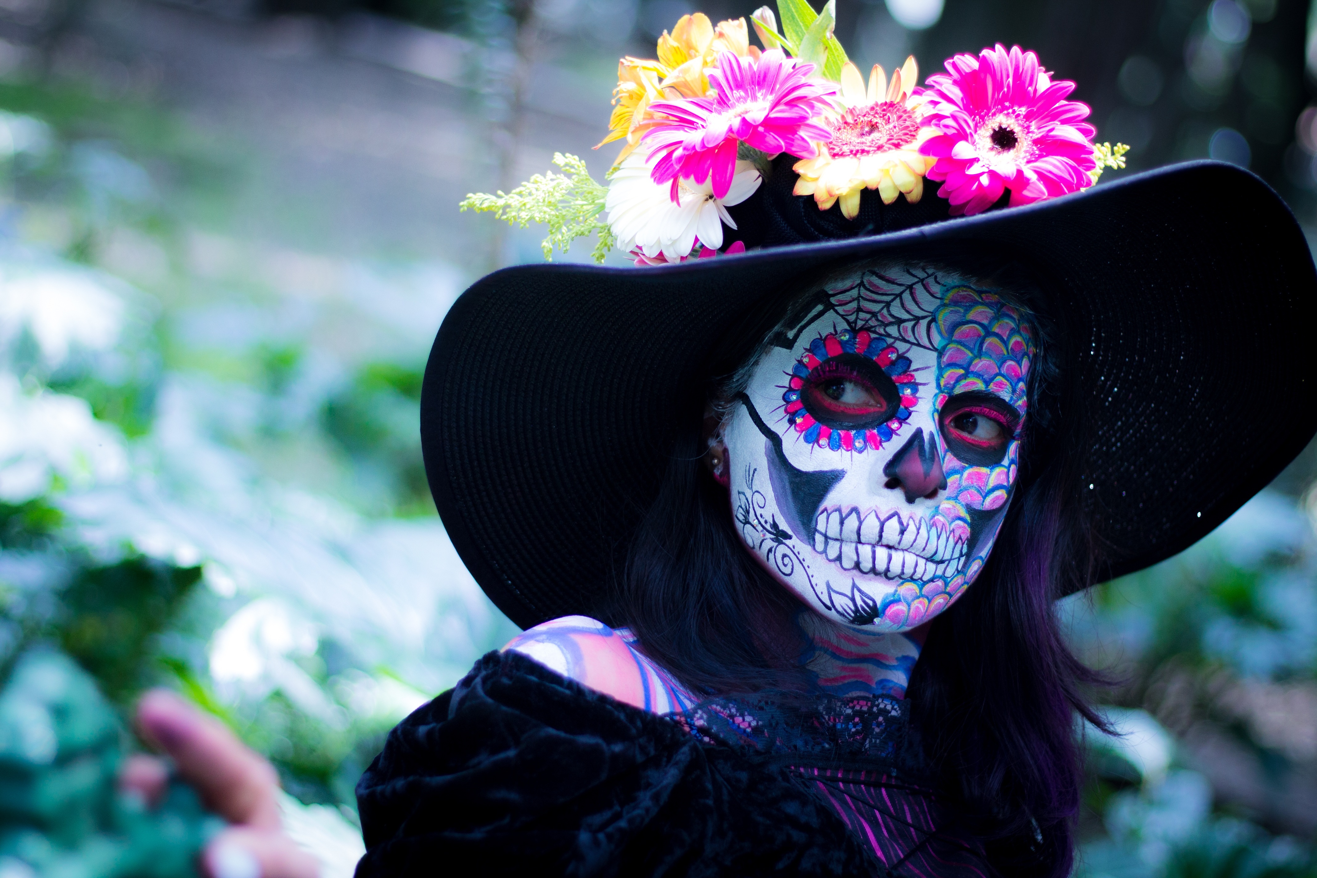 woman dressed in costume and full makeup for halloween as day of the dead