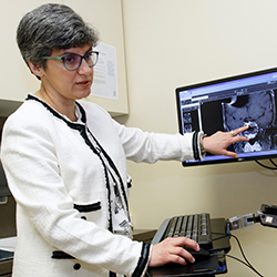 Dr. Maria Fleseriu in a clinic pointing at a monitor with an imaging test