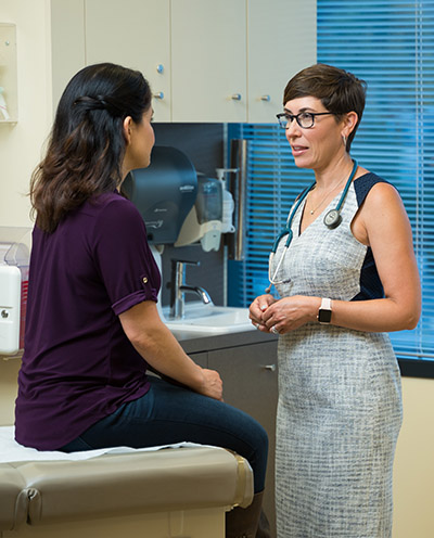 Dr. Laurel Hallock-Koppelman, OHSU family practitioner, talks with a patient in a clinical office