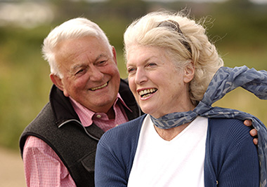 An older couple outdoors, smiling