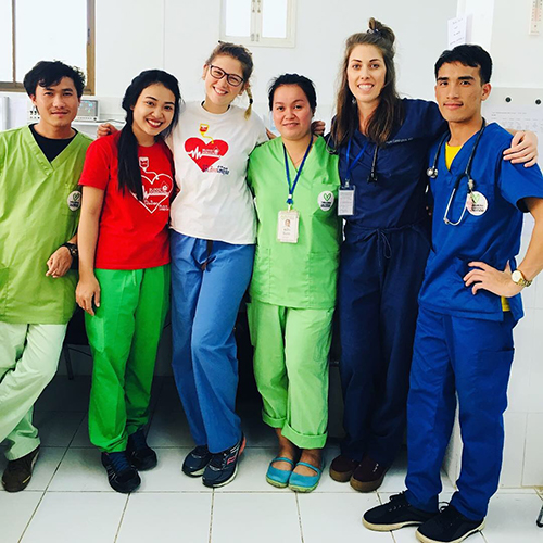 Six pediatric residents in a line with their arms around each others' shoulders.