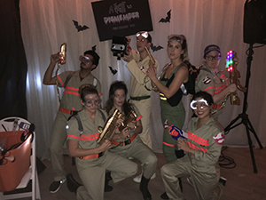 A group of people pose wearing Ghostbuster costumes.