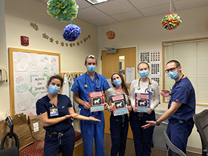 Five Pediatric Interns pose in clinic wearing PPE facemasks.