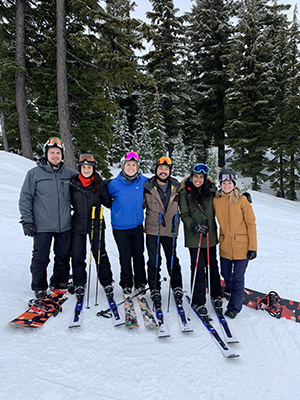 A group of people posing in a line while skiing and snowboarding on Mt. Hood.