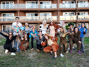 A group of OHSU Pediatric Residents pose outside a hotel wearing costumes.