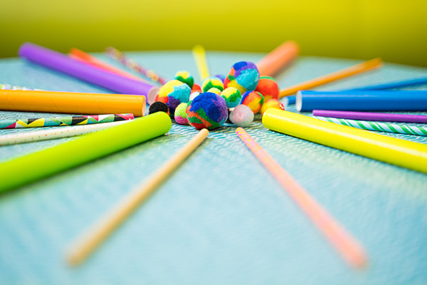 Photo of straws and fuzzy pompoms arranged in a circle.