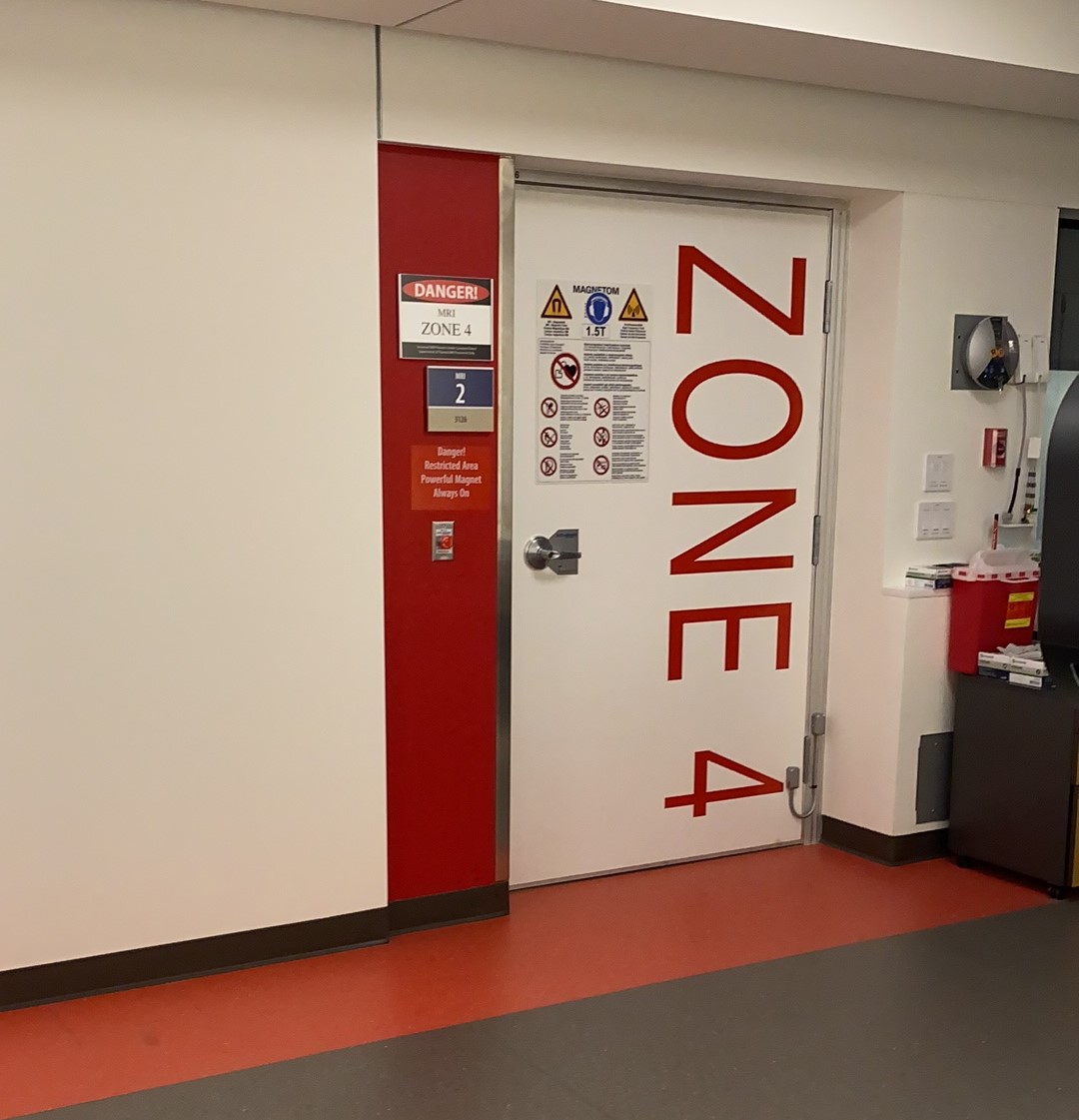 A door with red left-side panel and red floor tiles outlining it. The words, "Zone 4" are written in extra large red print down the right-hand side of the door.