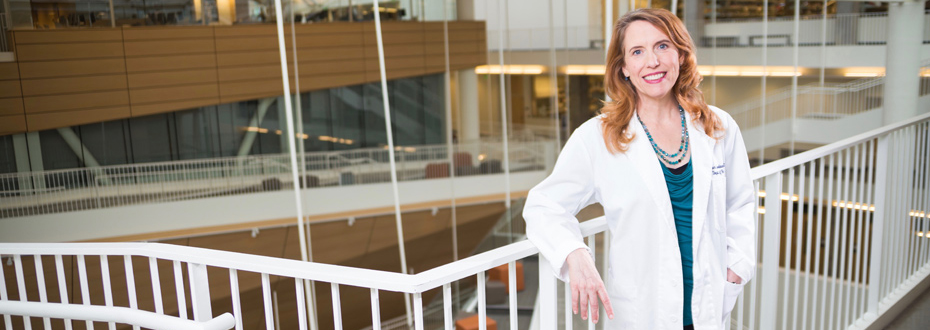 Allison Lindauer, wearing a white coat, standing inside the Robertson Collaborative Life Sciences Building