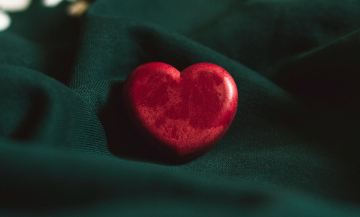 Support Resources - Stock photo of a red heart figurine on a green background