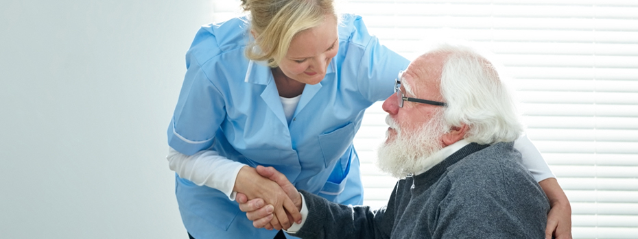 A healthcare provider helps an elderly patient.