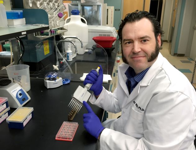 Dr. Brian O'Roak sits in his lab.