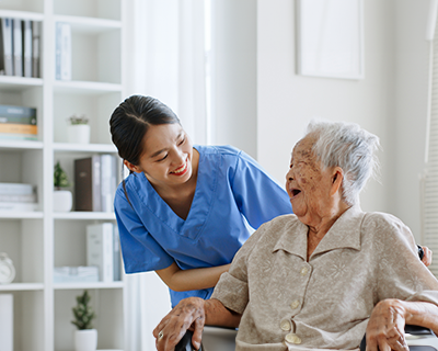nurse, caregiver, carer of nursing home talking with senior Asian woman feeling happy at home
