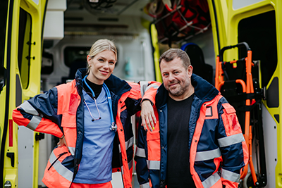 Portrait of rescuers, colleagues in front of ambulance car.