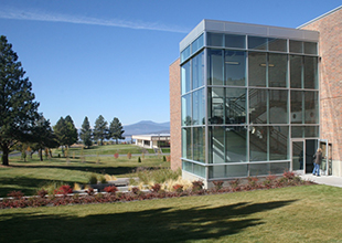 A photo of the Klamath Falls campus on a sunny day with several trees and grass.