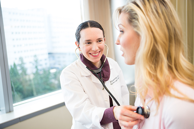 Dr. Elizabeth Munro, of the OHSU Knight Cancer Institute listenting to a patient's heart beat.