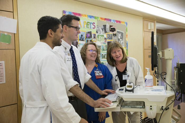 Medical scribes team looking at computer