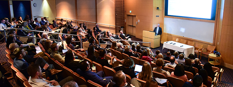 A speaker provides a lecture to an audience of medical professionals.