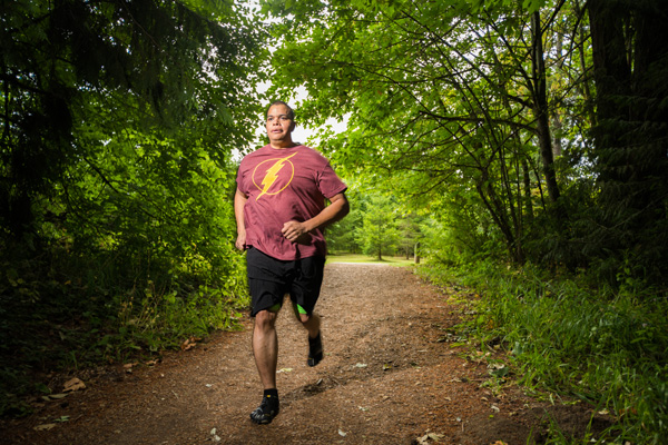 Winter Rhodes running along a trail in a forest