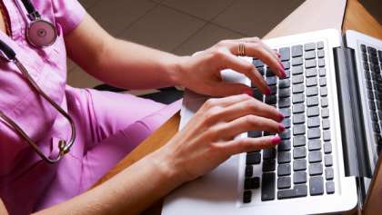 Nurse typing on laptop