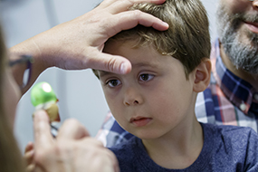 Boy with inherited blinding eye disease gets an exam at Casey Eye Institute. 