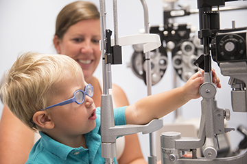 Young boy playing with equipment before his eye exam.