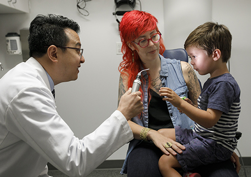 Dr. Yang examines young boy who receives gene therapy treatment at Casey