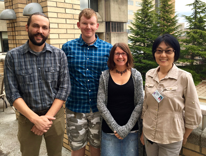 Group photo of researchers from the Nice Lab, smiling on a balcony outside of Richard Jones Hall.