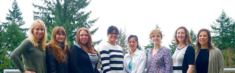 Group photo of the researchers of Rosenzweig Lab, standing outside with trees in the background.