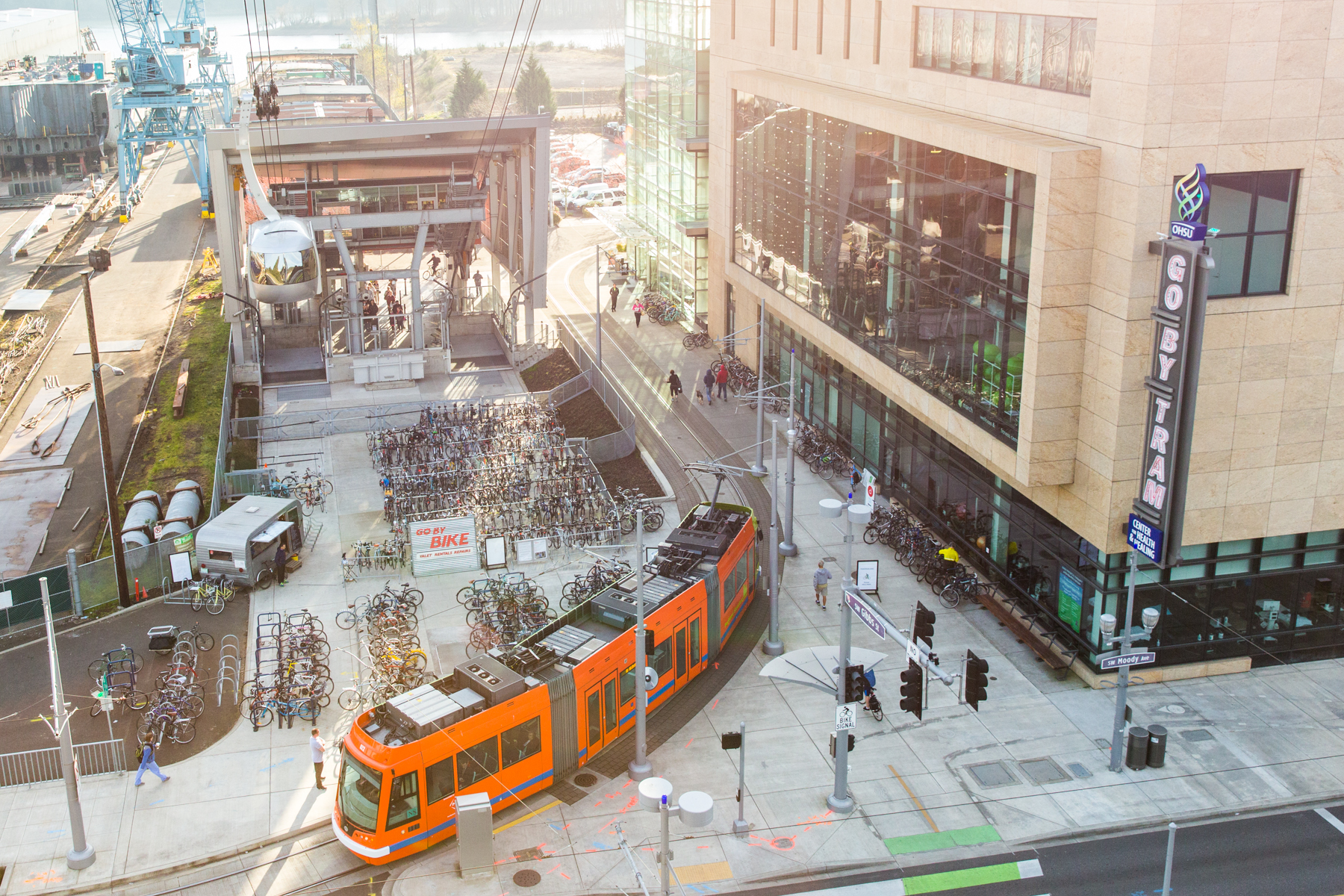 View from Portland Aerial Tram tower of orange Portland streetcar, bicycle parking and the Center for Health & Healing, which house march wellness & fitness center.