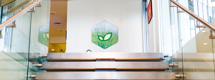 View from ascending the staircase to march wellness & fitness center with green leaf logo.