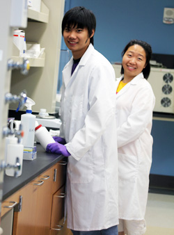 Two researchers smiling while working in Yantasee Lab.