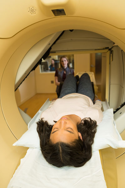 Patient point-of-view in Nuclear Medicine and Molecular Imaging scanner with tech in the far background