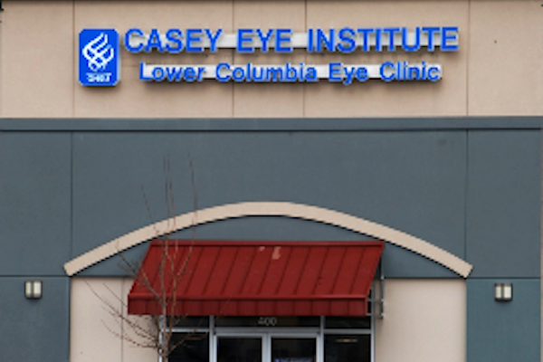 Front of a building with a sign that reads "Casey Eye Institute Lower Columbia Eye Clinic" in blue.