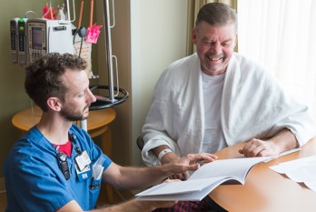 Nursing looking at paperwork with smiling patient 