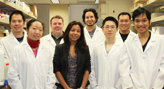 A group photo of eight Yantasee Lab researchers smiling in the lab.