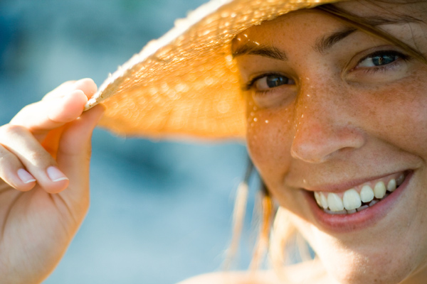 Woman smiles while wearing sun hat
