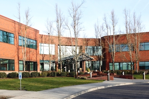 A brick building with trees in front of it in the winter.