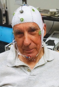 Ed Parker wears a hood studded with electrodes as part of a study.