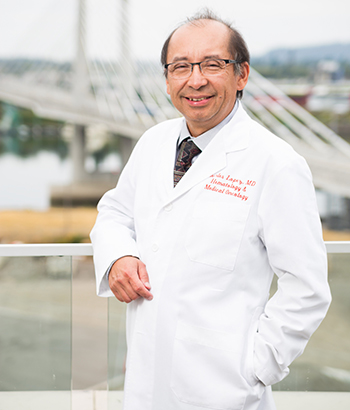 A make doctor standing with Tilikum Crossing in the background.