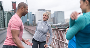 A small group of runners warm up for exercise on hawthorne bridge in Portland | Un pequeño grupo de corredores se calientan para hacer ejercicio en el puente Hawthorne en Portland